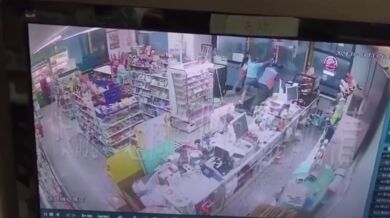 Pracovníci prodejny 7-Eleven drží dveře, načež je následně odfoukl tajfun Krathon