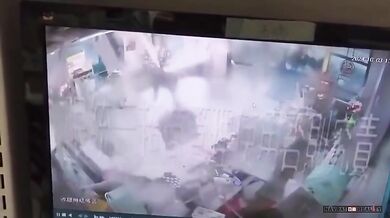 Pracovníci prodejny 7-Eleven drží dveře, načež je následně odfoukl tajfun Krathon