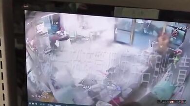 Pracovníci prodejny 7-Eleven drží dveře, načež je následně odfoukl tajfun Krathon