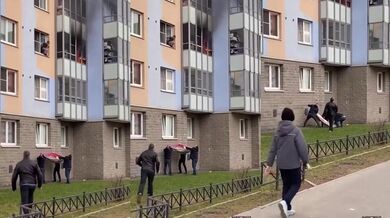 Hrdinové ze sousedství zachytili chlapce skákajícího z hořícího bytu v Rusku