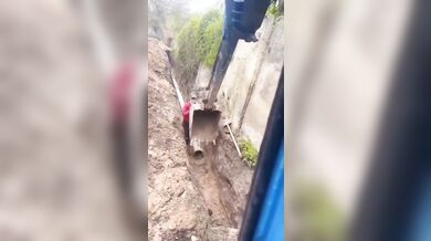 Lžíce stroje zachránila dělníka před zřícením zdi