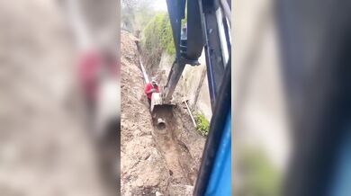 Lžíce stroje zachránila dělníka před zřícením zdi