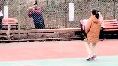 Starší muž ukazuje dětem, jak se střílet na basketbalový koš