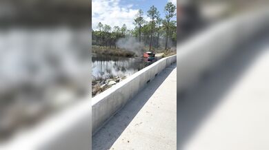 Hašení hořícího grilu na korbě auta na Floridě: Řidič couvnul s vozem rovnou do řeky