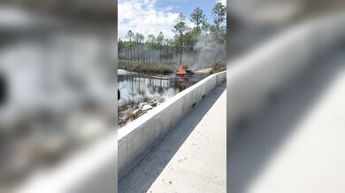 Hašení hořícího grilu na korbě auta na Floridě: Řidič couvnul s vozem rovnou do řeky